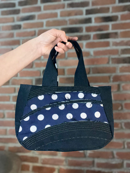 Petit sac à main fait de denim recyclé. Design avec petits pois blanc. Écoresponsable.