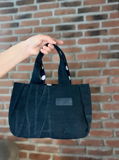 Petit sac à main fait de denim recyclé. Design avec petits pois blanc. Écoresponsable.